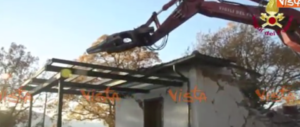 I vigili del fuoco radono al suolo con la ruspa una casa terremotata (video)