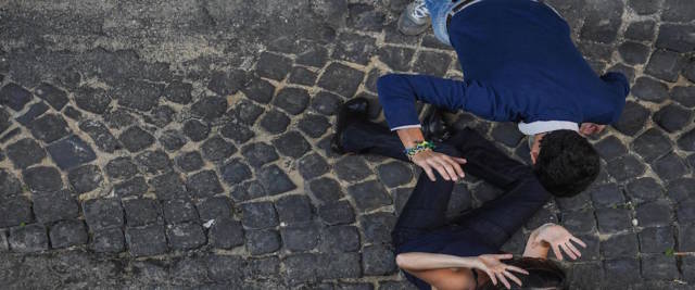 prende a calci la moglie incinta in strada foto Ansa