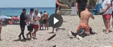 Migranti sbarcano sulla spiaggia, i bagnanti li bloccano. Sul barcone gli scafisti incappucciati (video)