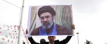 Un manifestante mostra la foto del figlio di Khamenei, Mojtaba, eletto nuova Guida suprema dell’Iran